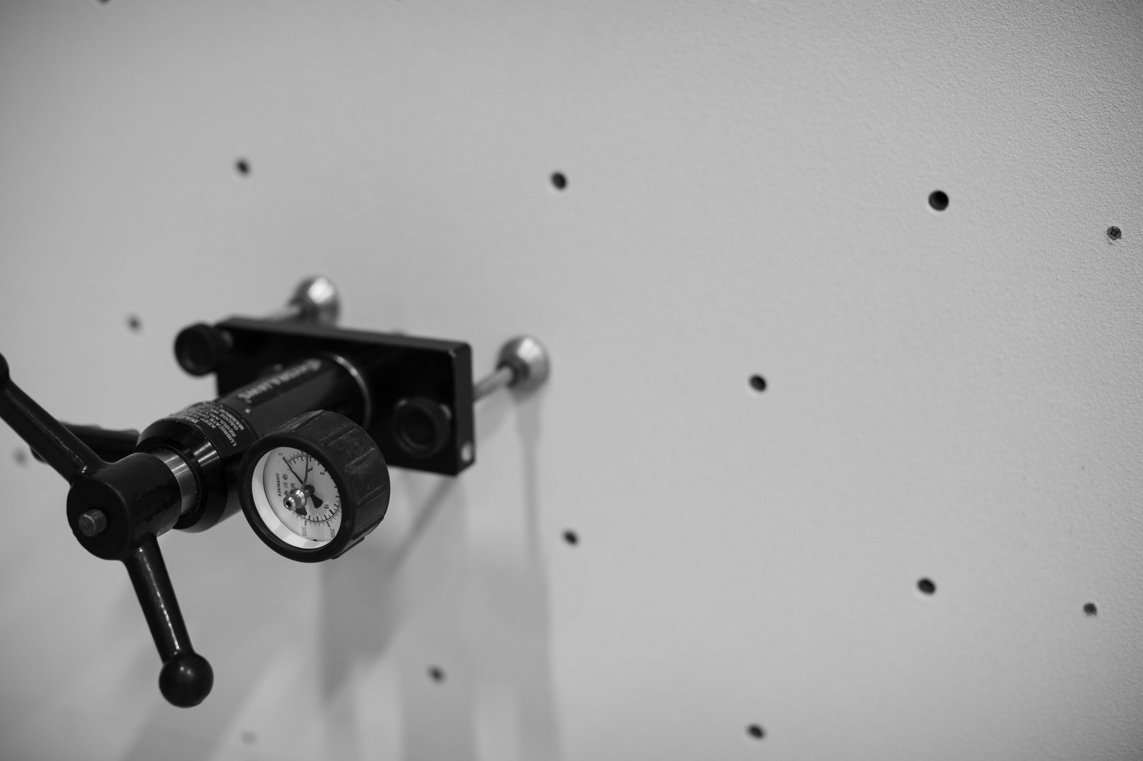 Close-up of a pull-test gauge against a climbing wall panel during an inspection to BS EN 12572